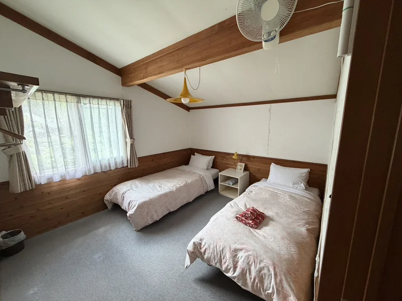 斜め天井が山小屋風のヒルナノーグ客室。ツインベッドの部屋